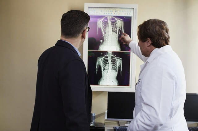 A doctor explains to a patient how the injury will affect his personal injury lawsuit.