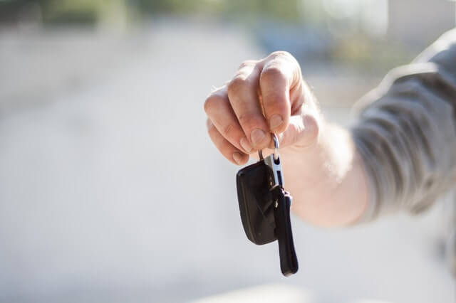 hand holding car key before rental car accident